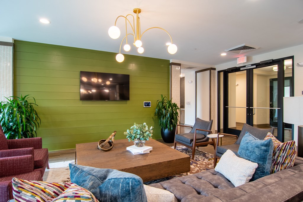 a living room filled with furniture and a large green wall