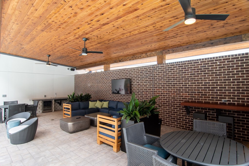 a patio with a wooden ceiling and brick walls