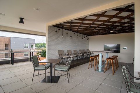 a bar with chairs and stools and a television on the wall