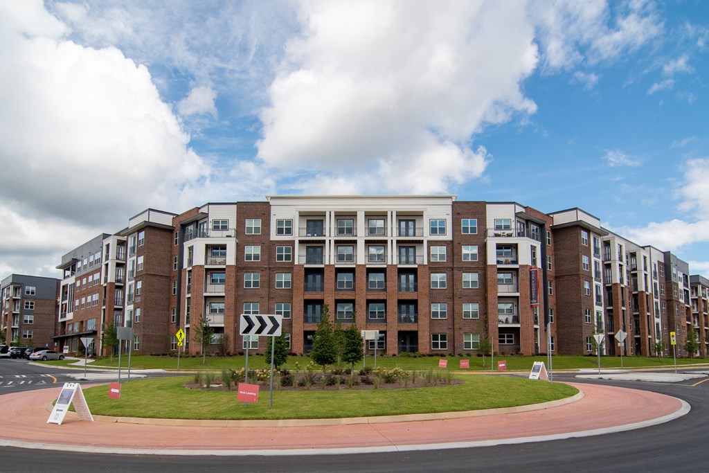 a large apartment building with a roundabout in front of it