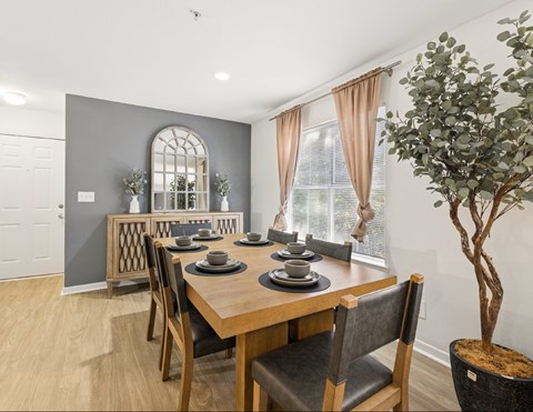A dining room with a wooden table and chairs.