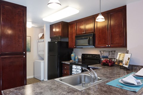 a kitchen with black appliances and granite counter tops and a sink