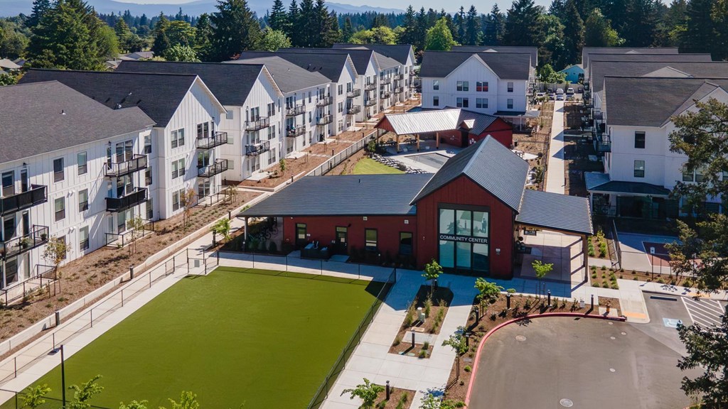 an aerial view of an apartment complex with green lawn and buildings at The Farmstead, Vancouver, WA
