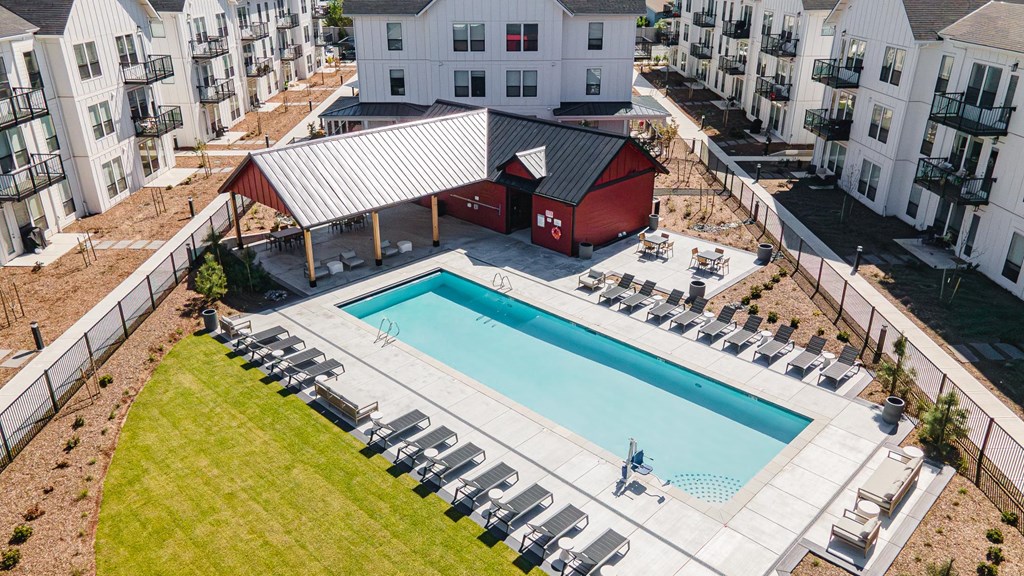 an aerial view of a swimming pool with an apartment building in the background at The Farmstead, Washington