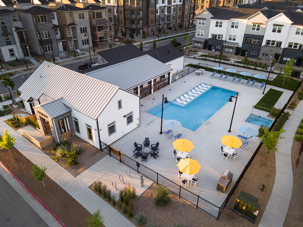 A swimming pool surrounded by a fence and umbrellas.