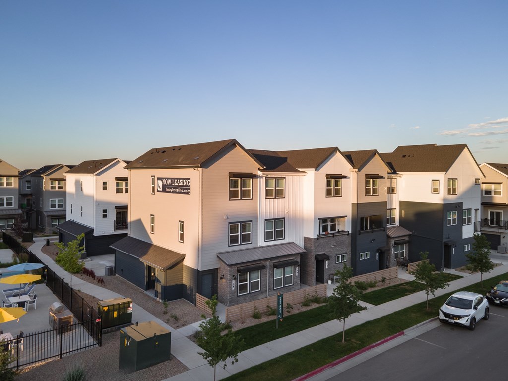 A row of modern houses with a clear blue sky above them.