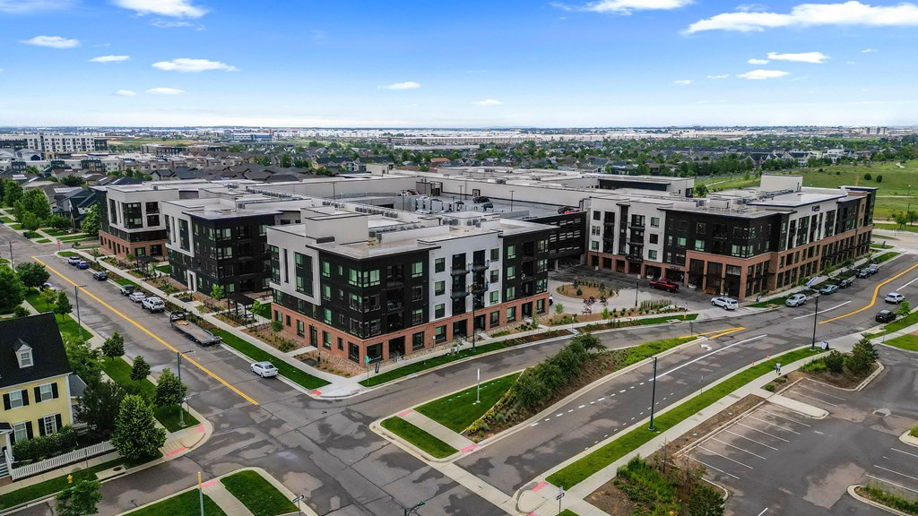 A large building complex with a parking lot in front.