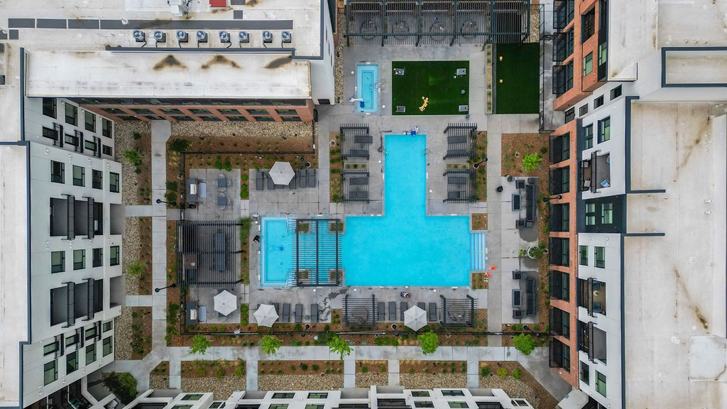 A blue pool in the middle of a courtyard surrounded by buildings.
