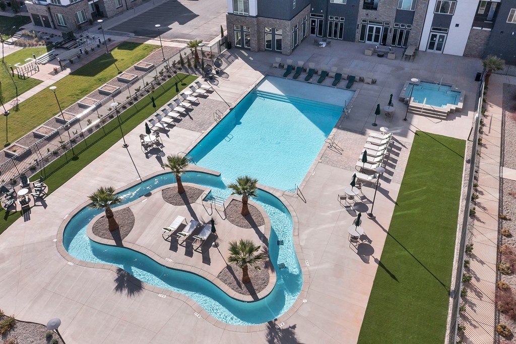 an aerial view of a swimming pool with chairs and palm trees