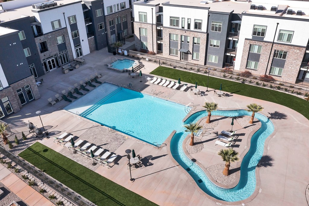 an aerial view of a swimming pool in front of an apartment building