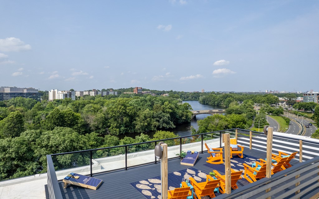 an outdoor deck with lounge chairs and a view of a river and trees