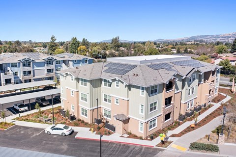 an aerial view of an apartment building with solar panels on the roof