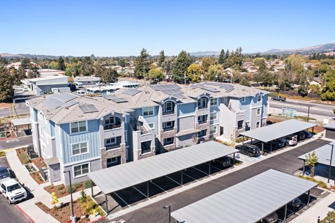 an aerial view of an apartment complex with blue and gray buildings and a street