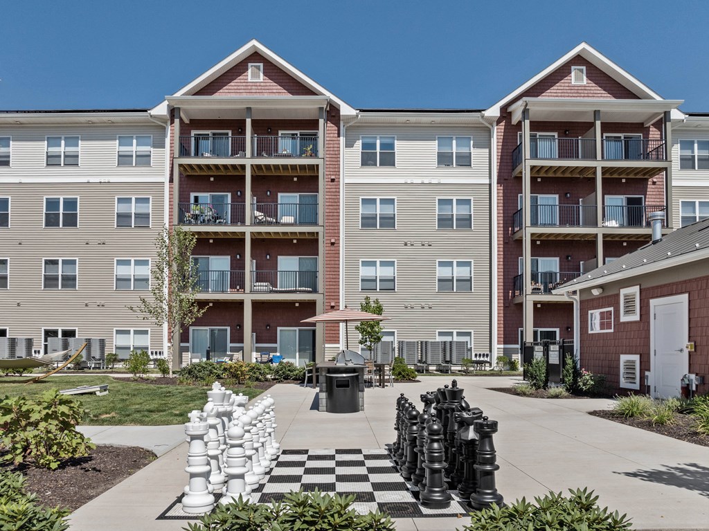 an outdoor chess court in front of an apartment building
