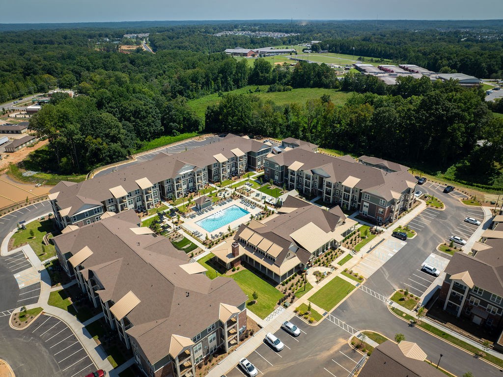 an aerial view of a hotel and apartments with a swimming pool