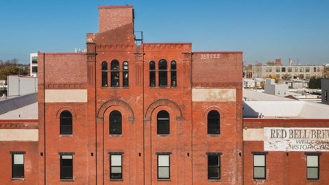 A red brick building with a sign that says "Red Bell Brew".