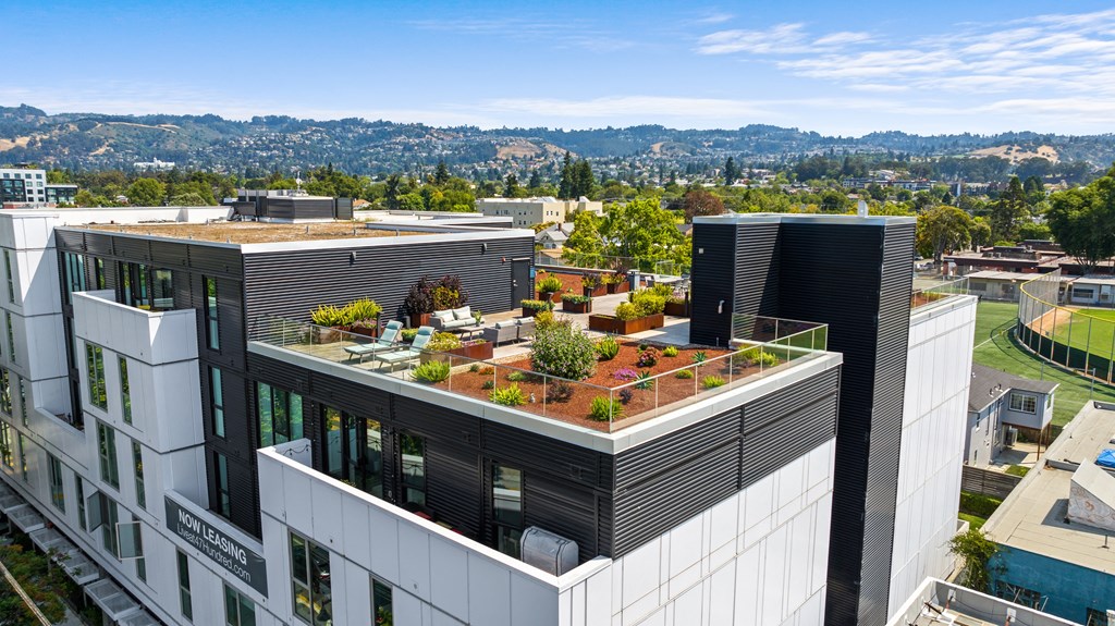 a building with a green roof with plants on top of it