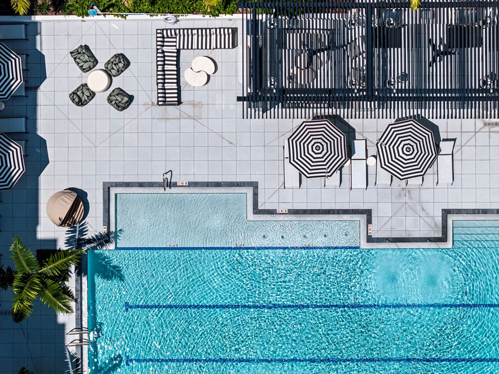 A pool with a black and white striped umbrella.