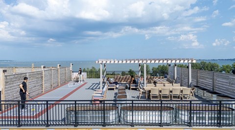 A man is standing on a bridge with a railing and a red line on the ground.