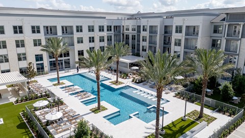 A large white building with a pool in front.