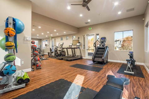 A spacious gym with a variety of equipment and a large mirror on the wall.