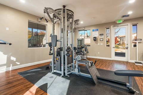 A gym with a weight machine and a bench.