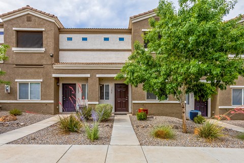 a building with a tree and a sidewalk in front of it