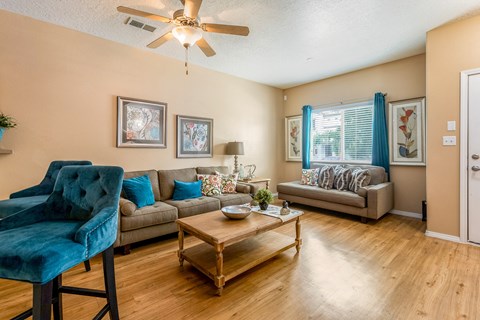 a living room with furniture and a ceiling fan