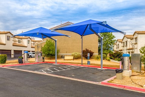 an empty parking lot with blue umbrellas in a parking lot