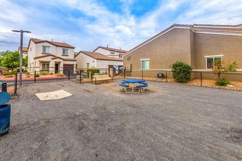 the backyard of a house with a picnic table and a fence