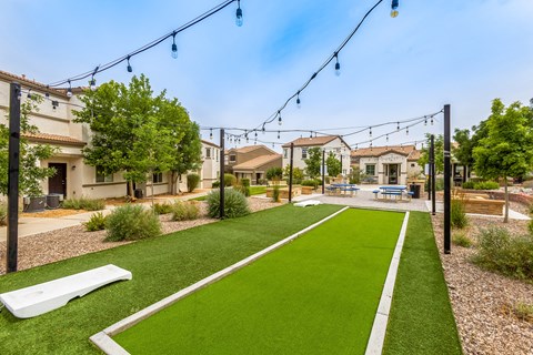 a yard with green grass and a picnic table and benches