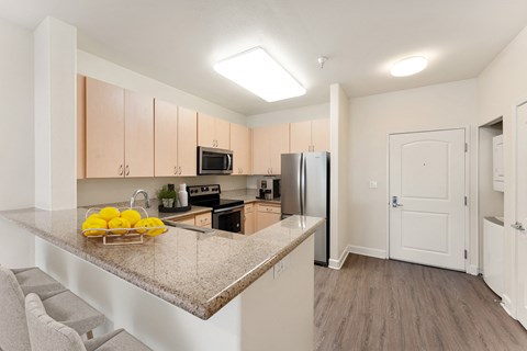 a kitchen with a granite counter top and a stainless steel refrigerator