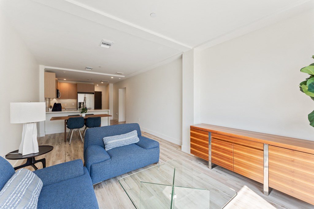 a living room with blue couches and a glass table