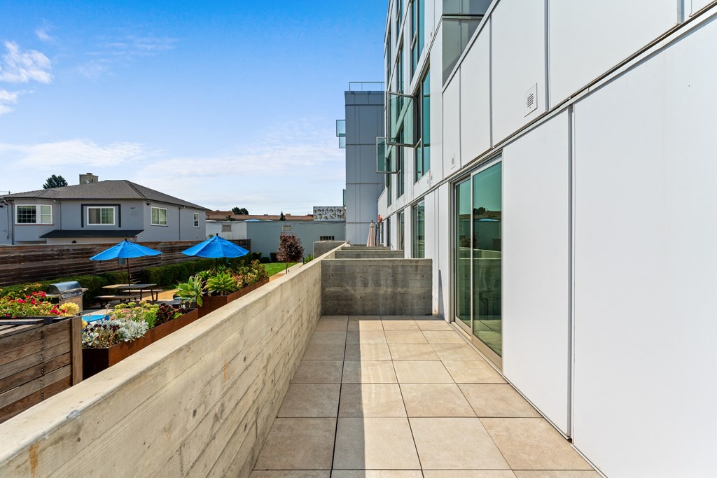 a balcony with a stone wall and a glass building