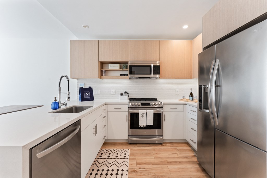 a modern kitchen with stainless steel appliances and white counter tops