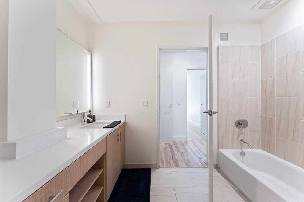 a bathroom with a tub and a sink and a mirror