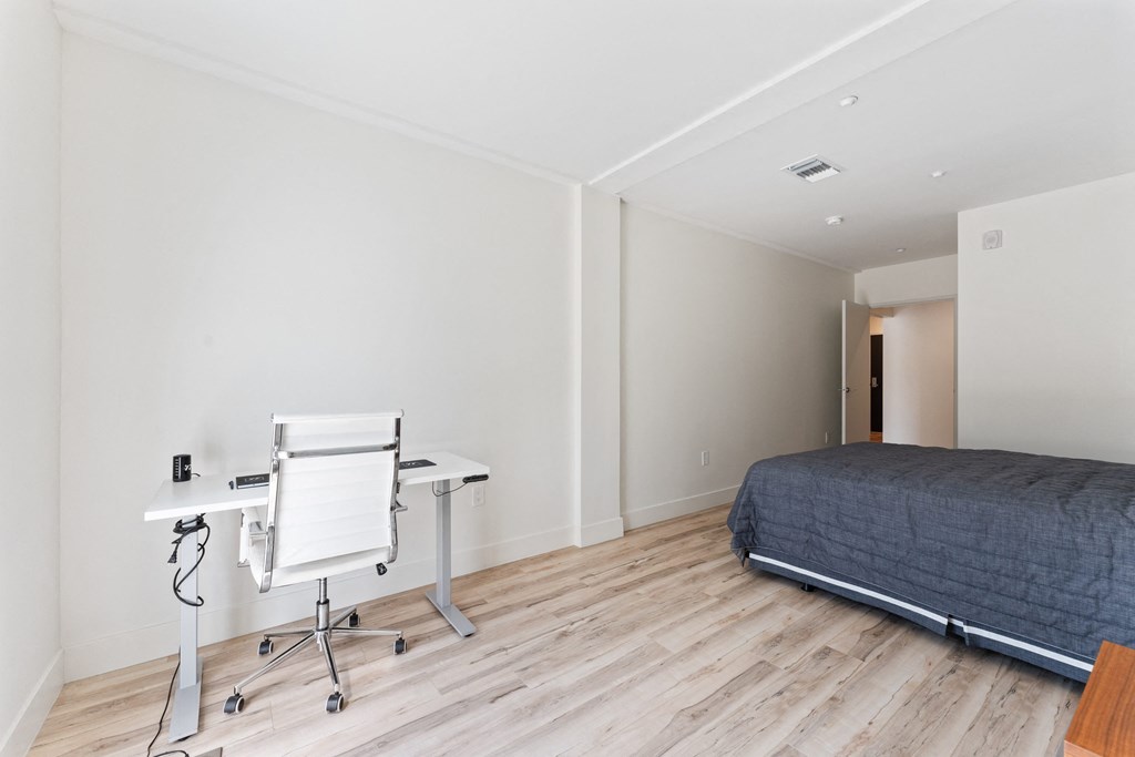 a bedroom with a bed and a desk with a chair