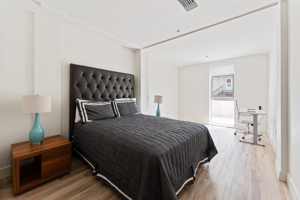 a bedroom with a large bed and a desk