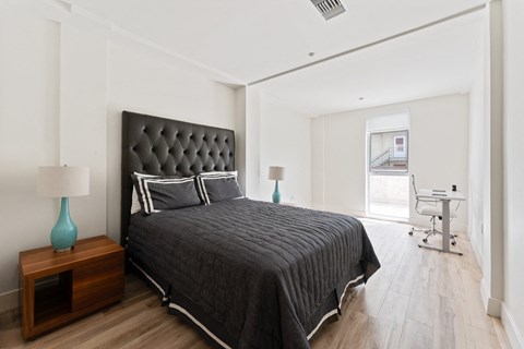 a bedroom with a large bed and a desk