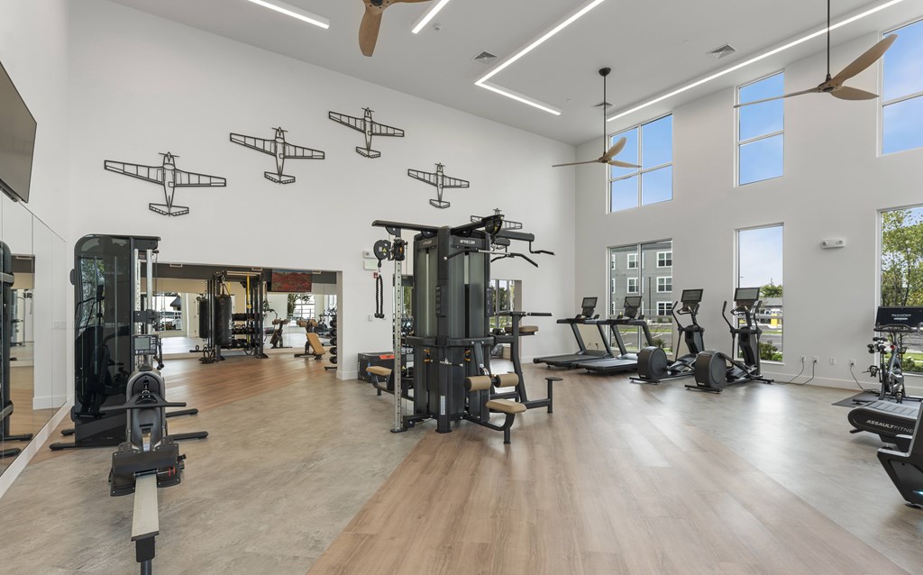 A spacious gym with a variety of equipment and a large mirror on the wall.