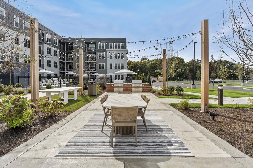 A patio with a table and chairs is in front of a building.