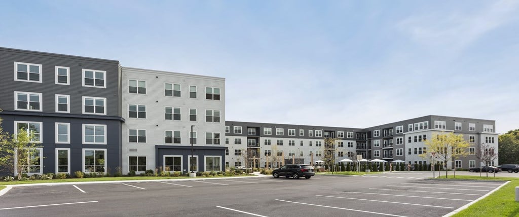 A parking lot in front of a multi-story building.