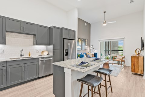 A modern kitchen with a large island and bar stools.
