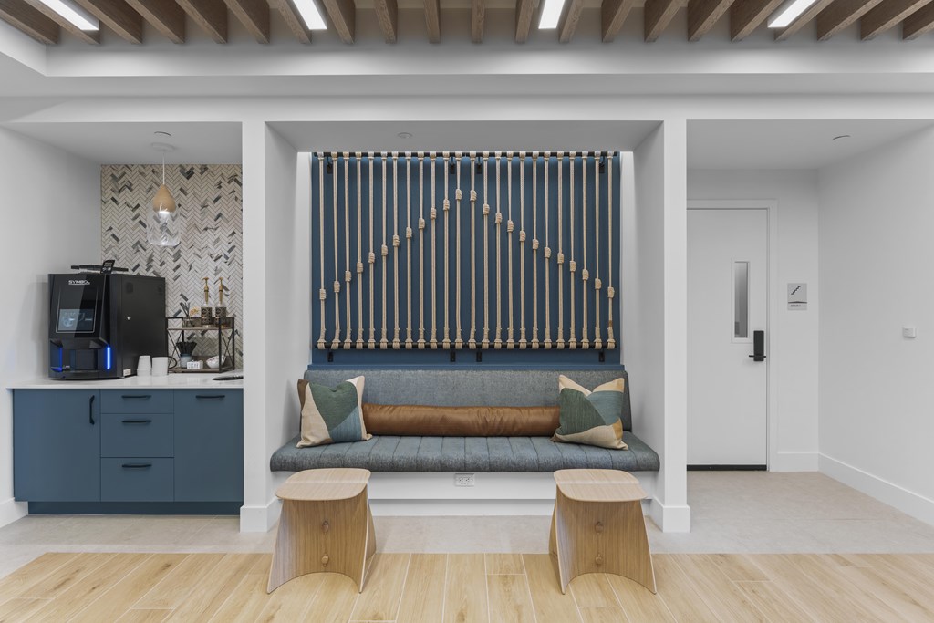 A modern living room with a sofa and a patterned wallpaper.