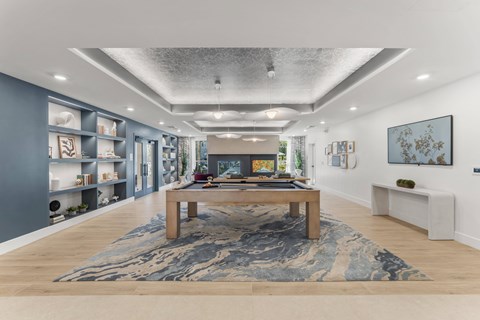 A modern living room with a pool table and a fireplace.