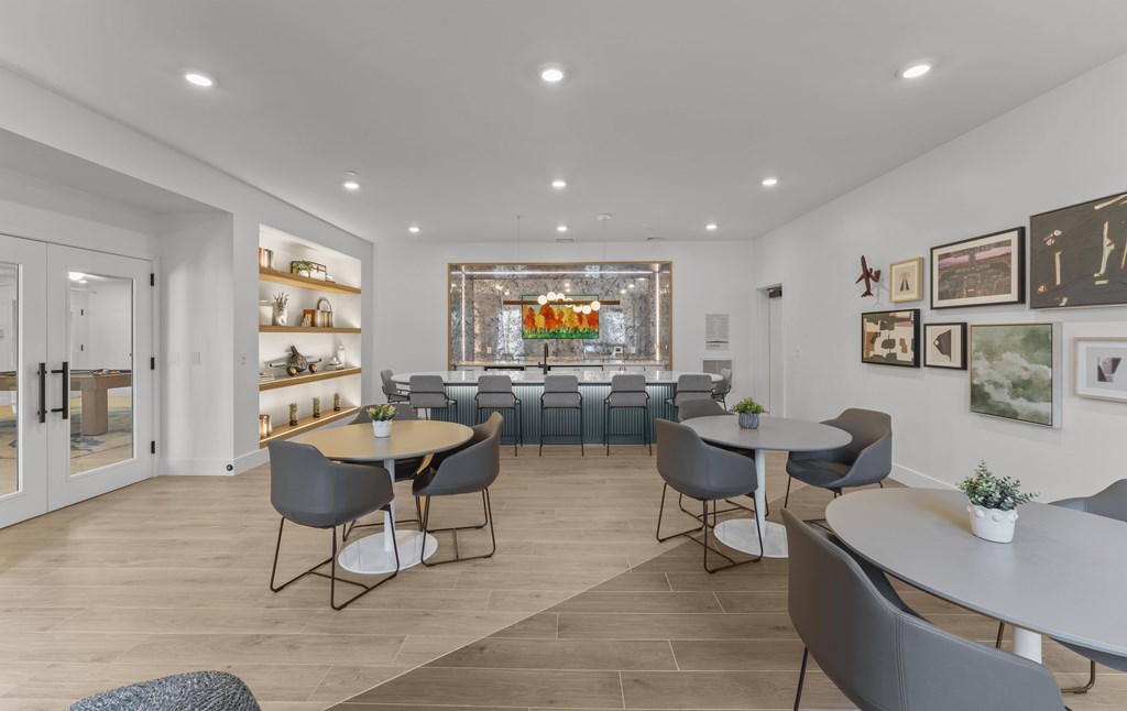 A modern dining room with a large table and grey chairs.