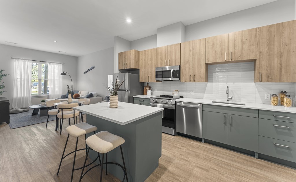 A modern kitchen with a large island and bar stools.