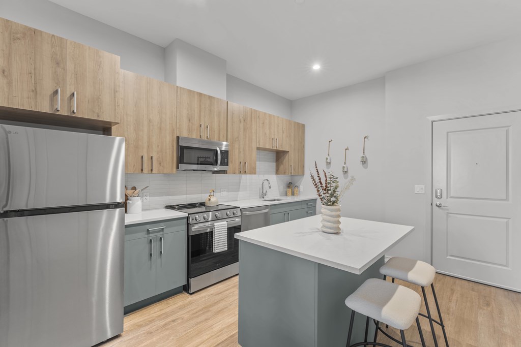 A modern kitchen with a refrigerator, stove, and oven.