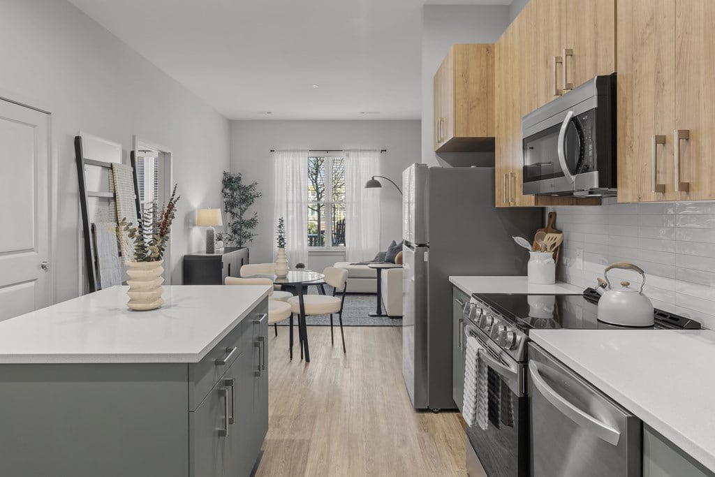 A modern kitchen with a grey countertop and wooden cabinets.
