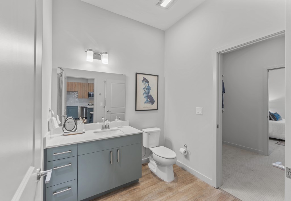 A bathroom with a toilet, sink, and mirror.